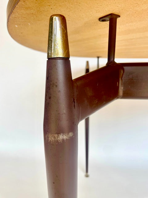 Sculptural brass detail and metal base of a Grant Featherston Aristoc Scape table supporting a laminate top