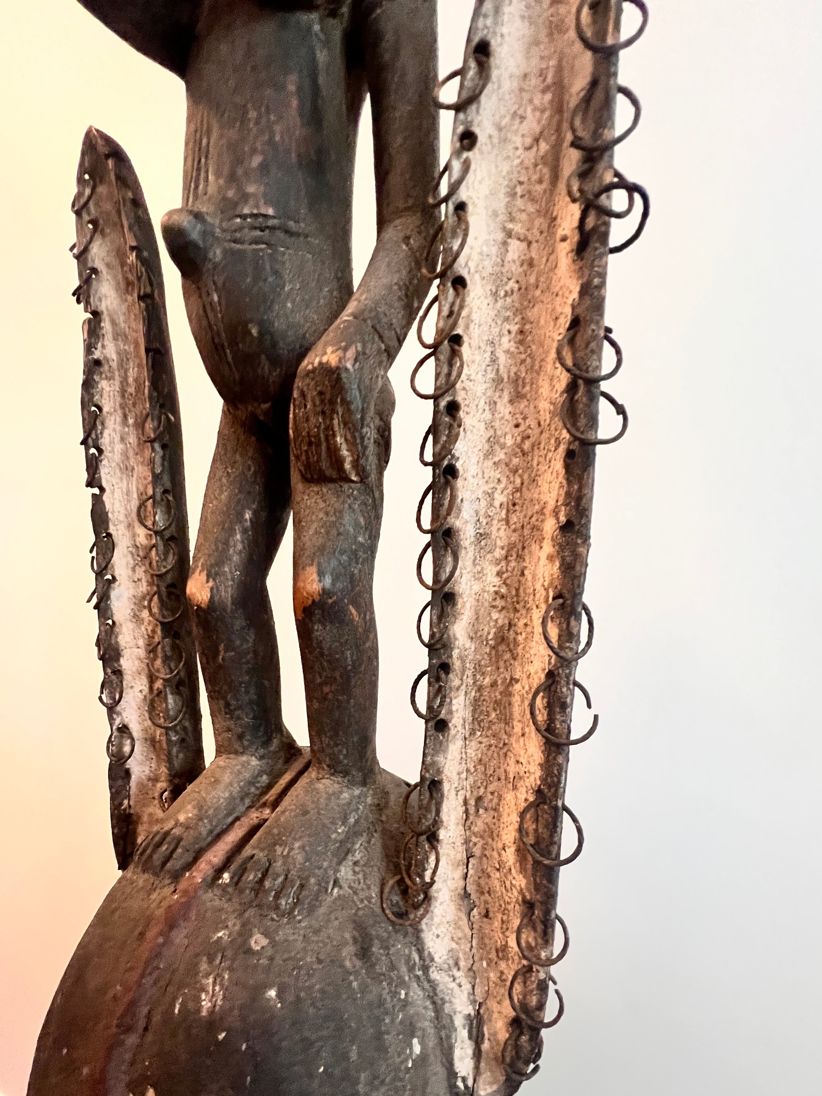 Dogon carved timber sculptural figure from Mali, surmounted female figure above mask form, displayed on metal stand detail showing metal rings