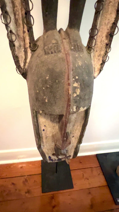 Clip of Dogon carved timber sculptural figure from Mali, surmounted female figure above mask form, displayed on metal stand